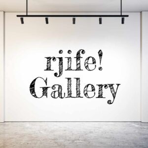 An image of a plain cream colored gallery wall with black lettering that reads "rjife! Gallery."
